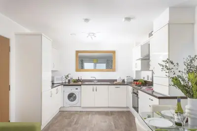a white kitchen with a sink and a dishwasher at 17 Astor Court, Newquay in Newquay