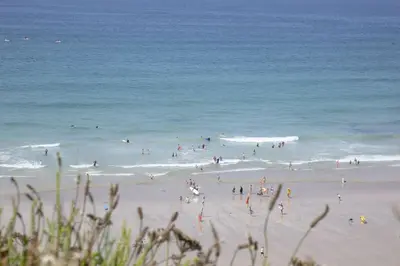 a group of people on a beach near the ocean at 17 Astor Court, Newquay in Newquay