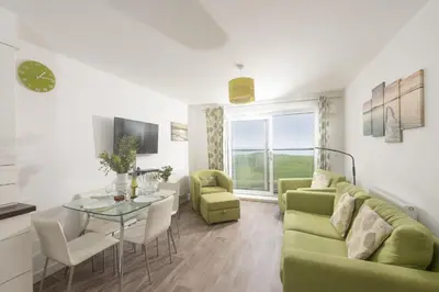 a living room with a green couch and a table at 17 Astor Court, Newquay in Newquay