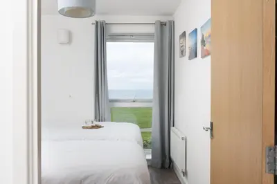 a bedroom with a view of the ocean at 17 Astor Court, Newquay in Newquay