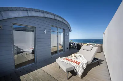 a house with a balcony with a bed and a couch at 66 Pentire, Newquay in Newquay