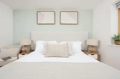 a bedroom with a large white bed with two lamps at 66 Pentire, Newquay in Newquay