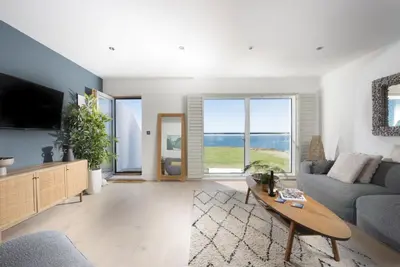 a living room with a couch and a table at 66 Pentire, Newquay in Newquay
