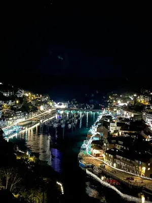 a view of a river at night with a city at Crows Nest Apartment, at Clipper House with free onsite allocated parking in Looe