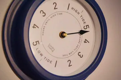 a clock that is hanging on a wall at Sandy Feet, St Eia Street. Cosy Cottage + Parking in St Ives
