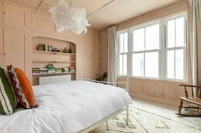a bedroom with a white bed and a large window at no.five Flushing in Flushing