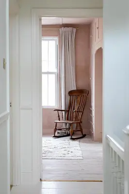 a rocking chair in a room with a window at no.five Flushing in Flushing