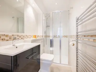 a white bathroom with a toilet and a shower at Pegasus in Falmouth