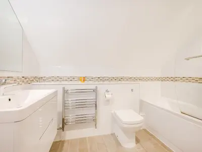 a white bathroom with a toilet and a sink at Pegasus in Falmouth