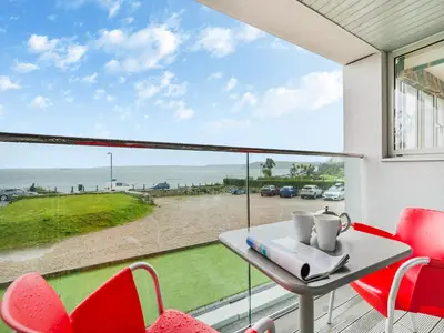 a table and chairs on a balcony with a view of the ocean at Pegasus in Falmouth