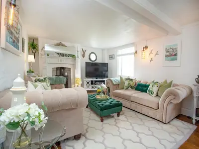 a living room with two couches and a tv at Spa Cottage in Mevagissey