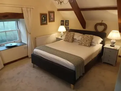 a bedroom with a large bed and a window at Cottage hideaway on the edge of Bodmin Moor in Launceston