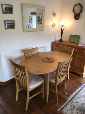 a wooden table and chairs in a room at Cottage hideaway on the edge of Bodmin Moor in Launceston