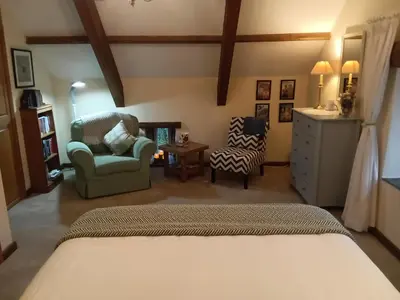 a bedroom with a bed and a chair and a table at Cottage hideaway on the edge of Bodmin Moor in Launceston