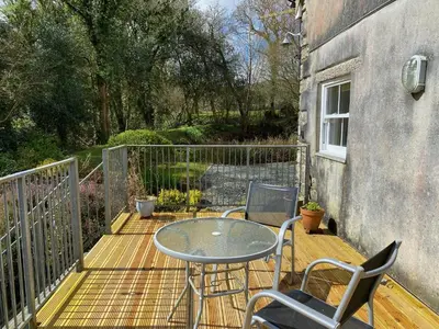 a patio with a table and chairs on a deck at Cottage hideaway on the edge of Bodmin Moor in Launceston