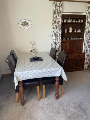 a dining room table with leather chairs and a tablecloth at Honeycomb Cottage - a quiet, charming, cosy retreat in the countryside only 2 miles from one of Cornwall's best beaches in Truro