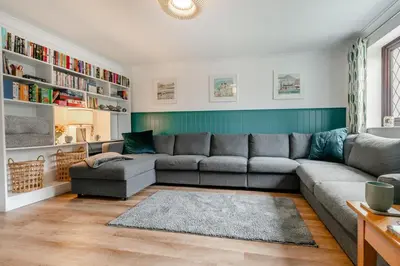 a living room with a gray couch and bookshelves at 3 Bed in Padstow oc-p29061 in Padstow
