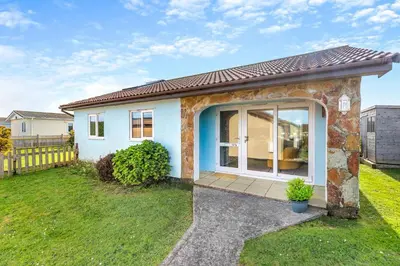 a small house with a large window in a yard at 3 Bed in St. Merryn oc-l29062 in St Merryn