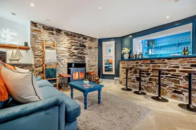 a living room with a blue couch and a stone fireplace at 7 Bed in St. Agnes oc-p28968 in St. Agnes