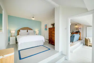 a bedroom with a white bed and a blue wall at 2 Bed in Downderry oc-p29018 in Downderry