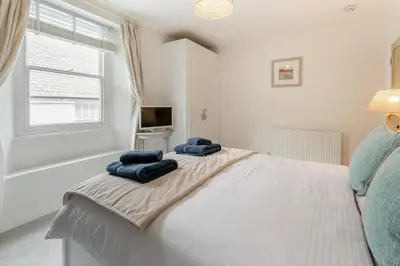 a bedroom with a bed with blue pillows on it at 2 Bed in Fowey oc-m29077 in Fowey