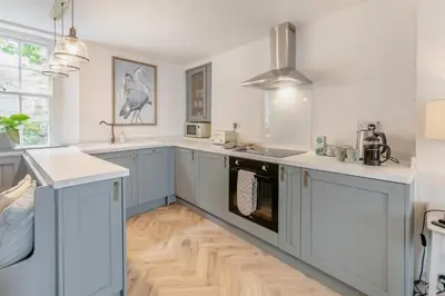 a kitchen with blue and white cabinets and wooden floors at 2 Bed in Fowey oc-m29077 in Fowey