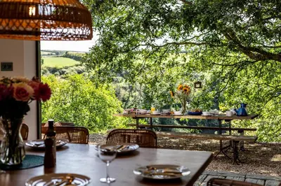 a table and chairs with a view of a tree at 5 Bed in Little Petherick oc-s29057 in Little Petherick