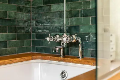 a kitchen sink with a faucet and green tiles at 5 Bed in Little Petherick oc-s29057 in Little Petherick