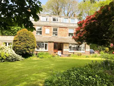 a large brick house with a green yard at Elerkey Guest House in Veryan