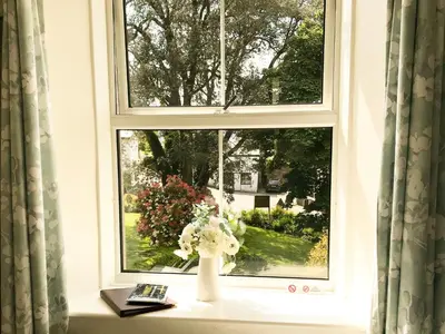a vase of flowers sitting on a window sill at Elerkey Guest House in Veryan
