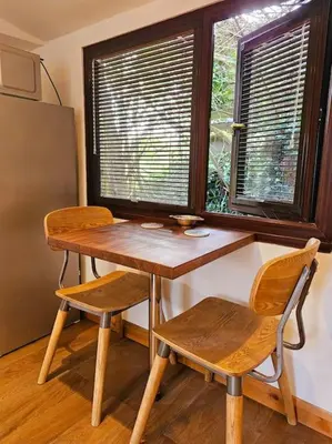 a wooden table and two chairs in front of a window at Treetops Lodge, private Cornish hideaway, parking, garden in Truro