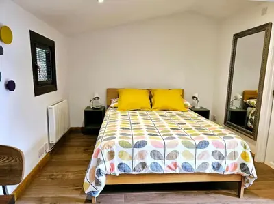 a bedroom with a bed with yellow pillows and a mirror at Treetops Lodge, private Cornish hideaway, parking, garden in Truro