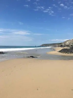 a sandy beach with the ocean in the background at Treetops Lodge, private Cornish hideaway, parking, garden in Truro