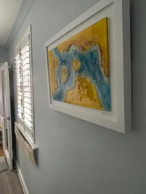 a painting hanging on a wall next to a window at Little Jem Harlyn Bay near 7 Bays in St Merryn