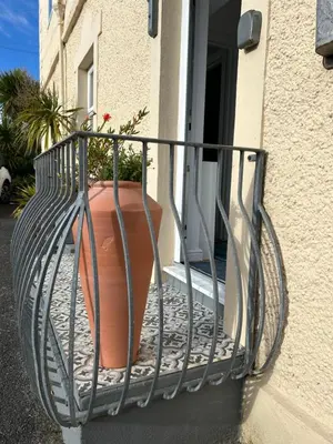 a balcony with a flower pot on the side of a building at Little Jem Harlyn Bay near 7 Bays in St Merryn