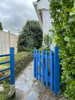 a blue fence in front of a house at Little Jem Harlyn Bay near 7 Bays in St Merryn