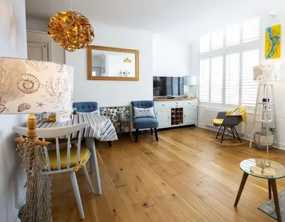 a living room with a dining table and chairs at Little Jem Harlyn Bay near 7 Bays in St Merryn