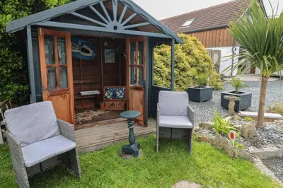 two chairs and a gazebo in a garden at Cuckoo's Rest in Penryn