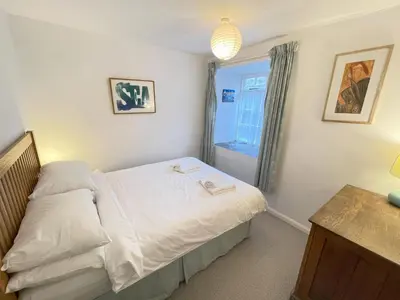 a small bedroom with a bed and a window at 3 Redfern Court in St Ives