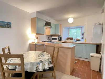 a kitchen with blue cabinets and a table and chairs at 3 Redfern Court in St Ives