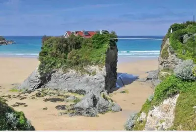 a house on top of a cliff on a beach at Palms 2 Private Garden Parking Central Newquay in Newquay