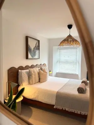a bedroom with a bed and a mirror at Palms 2 Private Garden Parking Central Newquay in Newquay