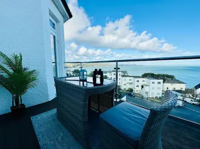 a balcony with a view of the ocean on a building at Luxury Sea View Apartment with Multi Room Balcony And Private Onsite Parking Only 300M From the Beach in Looe