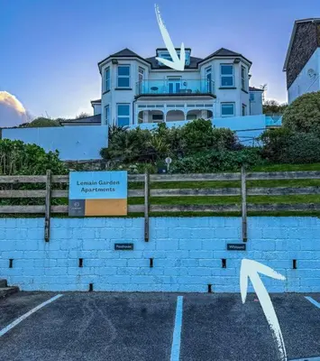 a large house with a sign in front of it at Luxury Sea View Apartment with Multi Room Balcony And Private Onsite Parking Only 300M From the Beach in Looe