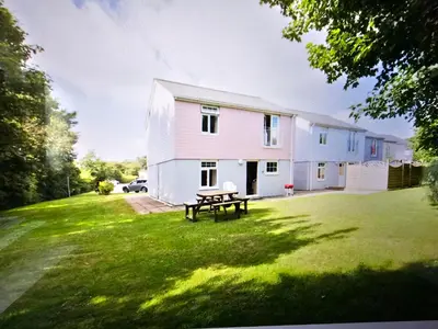 a white house with a picnic table in the yard at Atlantic Reach Gold Lodge 12 in Newquay