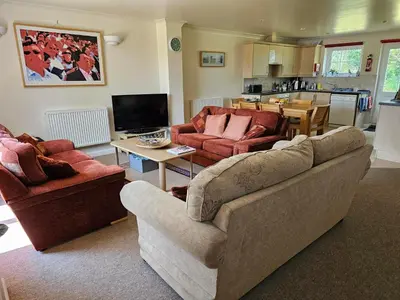 a living room with two couches and a kitchen at Atlantic Reach Gold Lodge 12 in Newquay