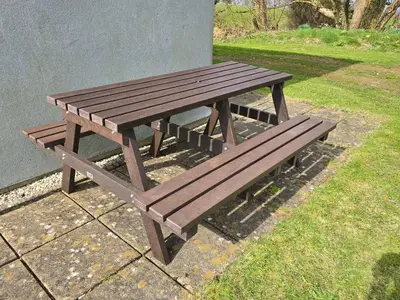a wooden picnic bench sitting next to a building at Atlantic Reach Gold Lodge 12 in Newquay