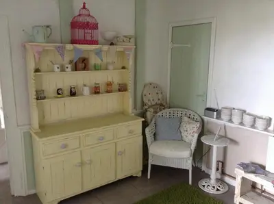 a room with a wooden dresser and a chair at Green Apple Bed and Breakfast in St Ives