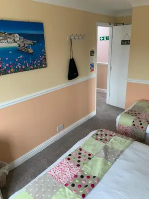 a bedroom with two beds and a painting on the wall at Green Apple Bed and Breakfast in St Ives