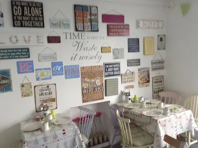 a room with two tables and a wall with signs at Green Apple Bed and Breakfast in St Ives